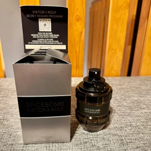 Spicebomb från Viktor & Rolf - Spicebomb från Viktor & Rolf är en herrparfym med en explosiv doftprofil. Flaskan är formad som en granat i svart och transparent glas. Doften har varma kryddiga toner av kanel och tobak, med inslag av sötma, läder och citrus. Perfekt för den som vill ha en kraftfull och unik doft. Oanvänd.