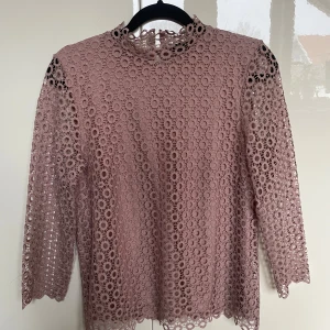 Rosa spetsblus från Stockh LM - Säljer en puderrosa spetsblus från Stockh LM. Blusen har trekvartsärmar och är i väldigt fint skick men bandet för ena knappen i nacken är dock sönder, verkligen inget man ser eller något som spelar roll då det är en till knapp💗