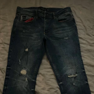 Mörkblå jeans från Koröshi - Snygga mörkblå jeans från Koröshi med slitna detaljer