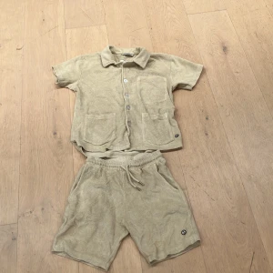 Beige frottéshorts från Emma och Malena  - Snygga beige shorts i frotté från Hummel. De har en bekväm elastisk midja med snörning och praktiska fickor. Perfekta för en avslappnad stil.