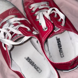Röda sneakers från Converse - Snygga röda Converse sneakers med klassisk design och vita snören. Perfekta för en avslappnad stil. De har en vit tåhätta och sula som ger en ikonisk look.