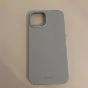 Ljusblått mobilskal från Holdit - Säljer ett stilrent ljusblått mobilskal från Holdit. Skalet är tillverkat i ett mjukt material som ger bra grepp och skydd för din telefon. Perfekt för dig som vill ha ett enkelt och snyggt skydd till mobilen. 💙