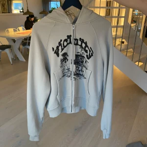 Beige hoodie med tryck från Vicinity - Säljer en beige hoodie från Vicinity med ett fräscht svart tryck. Hoodien har dragkedja och långa ärmar, perfekt för en avslappnad stil. Den är i storlek medium och har en bekväm passform. Tröjan är i toppskick och köptes nypris för 1199, säljs nu endast för 599! Skriv vid frågor! Personen på bilden är 175 cm lång o väger 80!