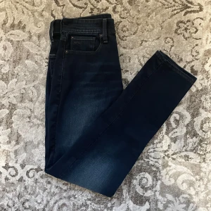 Mörkblå jeans från G-Star RAW - Snygga mörkblå jeans från G-Star RAW med klassisk femficksdesign. Jeansen har en diskret tvättad look och är perfekta för en stilren vardagsoutfit. De har en normal passform och är tillverkade i ett slitstarkt denimtyg.
