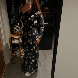 Blommig långklänning från Selected Femme - Säljer denna marinblåa långklänningen ifrån Selected Femme. Klänningen har långa ärmar och ett knytband i midjan för en smickrande passform. Klänningen har et tungt polyestertyg med snyggt fall💙🌸 Nypris 1299kr