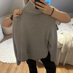 Grå stickad polotröja i kashmir - Säljer en mysig grå stickad polotröja med ribbade detaljer från zara Perfekt för kyliga dagar med sin höga krage och långa ärmar. Tröjan är i storlek S och passar utmärkt till både jeans och kjol. 100% kashmir