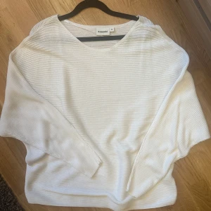 Vit ribbad tröja från Kappahl - Säljer en stilren vit ribbad tröja från Kappahl. Tröjan har en avslappnad passform med långa ärmar och en rund halsringning. Perfekt för en enkel och bekväm look. Passar bra till både jeans och kjol.