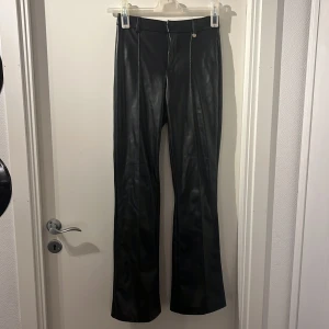 Svarta skinnbyxor från ONLY - Snygga svarta skinnbyxor från ONLY i storlek XS. Byxorna är mid waist. På bild 3 kan man se att sömar har släpp som man lätt kan sy och fixa själv. Nypriset är 500kr