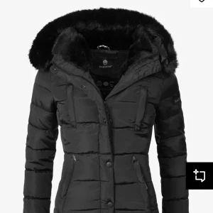 Svart dunjacka från Marikoo - Snygg svart dunjacka från Marikoo med pälskantad huva. Jackan har en figurnära passform och stängs med dragkedja och knappar. Perfekt för kalla dagar med sin varma och stilrena design. Har gått sönder lite under armen ,fast har sytt och fixat den👍