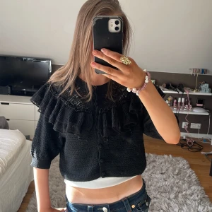 Svart kofta från Zara - Säljer en svart kofta från Zara med vackra volangdetaljer och spets. Koftan har knappar framtill och är perfekt när de blir lite varmare. Den är kortärmad och säljer för den inte kommer till användning❤️skriv om det är något ni undrar🥰