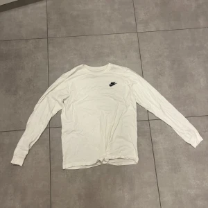 Vit långärmad tröja från Nike - Säljer en stilren vit långärmad tröja från Nike. Tröjan är i en mjuk och bekväm bomullsmix. Den är i storlek S. Hör gärna av er om ni har några frågor. 