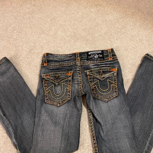 True Religion jeans - As coola svart/grå jeans från True Religion med orange sömmar. Har små tecken på användning men inget som syns tydligt. 😊