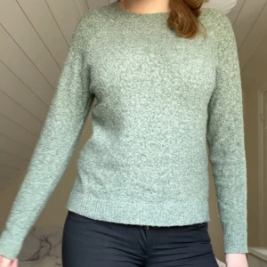 Grön stickad tröja - Säljer en mysig grön stickad tröja med rund hals och långa ärmar. Perfekt för kyligare dagar och enkel att matcha med olika outfits. Tröjan har en mjuk och bekväm passform.