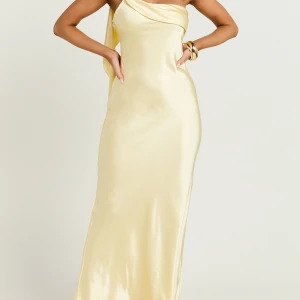 Bal klänning - En super fin gul satin klänning med  axelbandslös design och en vacker drapering över axeln. Perfekt för speciella tillfällen som t.ex bal eller bröllop. Aldrig använd med prislapp kvar 