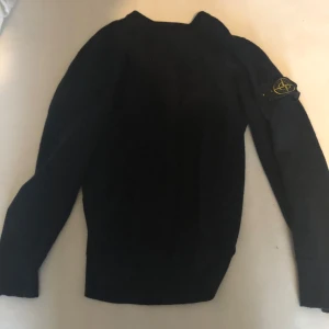 Svart tröja från Stone Island - Säljer en stilren svart tröja från Stone Island med deras ikoniska märke på ärmen. Tröjan har en klassisk design med långa ärmar och rund hals. Perfekt för en avslappnad och trendig look. Den är äkta. Bara andvändt 3-4 gånger finns ej kvitto pga den köpt på Plick tidigare