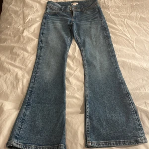 Blå jeansbyxor från Gina Tricot storlek 152  - Snygga blå jeansbyxor från Gina Tricot med bootcut-stil. De har en klassisk femficksdesign och är perfekta för en avslappnad look. Storlek 152.