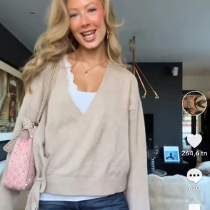 Beige omlottkofta - Säljer en stilren beige omlottkofta med knytband i midjan. Koftan är stickad och har långa ärmar, perfekt för en mysig och elegant look. Passar bra till både jeans och kjol.