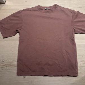 Två t-shirts från UNIQLO i olika färger - Säljer två t-shirts i olika färger. Den ena är brun och den andra är mörkgrå. Båda har en enkel design med rund hals och korta ärmar. Perfekta för en avslappnad stil. De är lite oversized. 100 per tröja men köper du båda kan du få billigare🤩