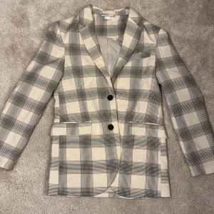 Rutig kavaj från Monki - Snygg rutig kavaj från Monki i svart och beige. Passar bra till både jeans och kjol. Riktiga fickor, ej sprättade fickor och sprund. Bara testade men aldrig använd. Säljer pågrund av att den är för stor då den är oversize. 