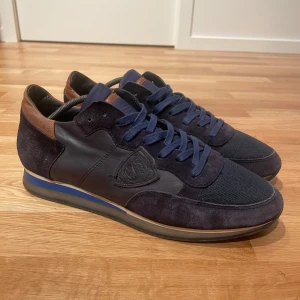 Philippe model skor - Philippe model trpz skor i färgen blå och läder brun. Skorna är i ett mycket bra skick utan några defekter. Storlek:43 nypris ca 3200kr, vårt pris endast 1300kr✅hör gärna av er vid eventuella funderingar eller frågor!