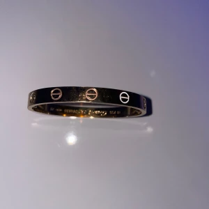 Guldarmband med skruvmönster - Elegant guldarmband med ett unikt skruvmönster runt om. Perfekt för att ge en stilren touch till din outfit. Armbandet har en slät och glänsande yta.