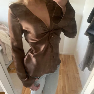 Brun långärmad blus - Snygg brun blus med lång ärm och knytning framtill.  Använd ett fåtal gånger så fint skick🥰