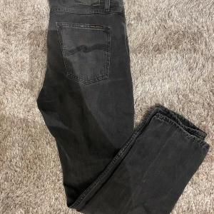 Svarta Nudie Jeans - Snygga svarta jeans från nudie jeans i modellen steadie eddie ii, bra skick förutom den slitna lappen som syns på bild 3. W31 och L30, nypris ligger på 1500