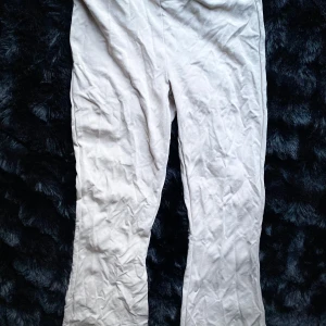 Beige byxor från Ginatricot basically basics - Säljer ett par stilrena beige byxor från basically basics. Byxorna är utsvängda och är tillverkade i ett mjukt material som ger en bekväm känsla. Perfekta för en avslappnad men ändå elegant look.