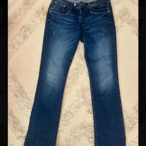 Bootcut jeans från ltb - Snygga blå bootcut jeans från ltb med klassisk femficksdesign och subtila slitningar. Perfekta för en avslappnad stil med en touch av retro. De har en knapp och dragkedja framtill. W30 L36 jag är 171 som referens lite långa men bara bra, tyvärr för stora i midjan för mig. Helt nya utan prislapp