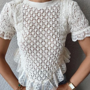 Vit spetsblus med volangdetaljer - Charmig vit spetsblus med korta ärmar och vackra volangdetaljer. Blusen har ett intrikat spetsmönster och en rund halsringning. Perfekt för en romantisk look. skriv för frågor eller fler bilder💗