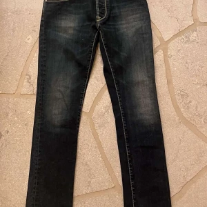 Mörkblå jeans från Tramarossa - Snygga mörkblå jeans från Tramarossa med klassisk femficksdesign och kontrastsömmar. Jeansen har en rak passform och är tillverkade i ett slitstarkt denimtyg. Perfekta för en stilren look. Lägst 1200kr vid snabb affär. Ny pris runt 5500kr.