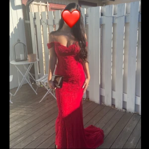 Röd spetsklänning - Säljer min fantastiska röda balklänning med spetsdetaljer och offshoulder-design. Klänningen har en figurnära passform och en elegant slits. Perfekt för speciella tillfällen. klänningen är i storlek 38, men passar mig jättebra som är en 34/36. Skriv till mig för fler bilder 🥰