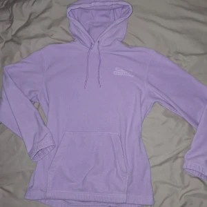 Lila hoodie med tryck - Säljer en mysig lila hoodie med texten 'Be Kind to Your Mind' tryckt på ryggen. Hoodien har en klassisk design med känguruficka och justerbar huva med dragsko. Perfekt för en avslappnad stil.