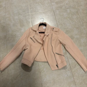 Rosa bikerjacka från Reserved - Snygg rosa bikerjacka från Reserved i storlek XS. Jackan har en asymmetrisk dragkedja och flera dragkedjefickor för en cool look. Använd några gånger, säljer pga att jag ej använder längre.