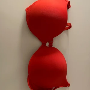 Röd bh med justerbara axelband - Snygg röd bh med vadderade kupor och justerbara axelband. Perfekt för en bekväm passform och extra stöd. Gjord i ett mjukt och stretchigt material.