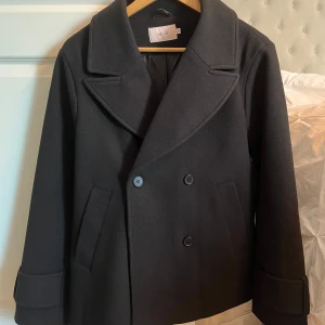 Svart kappa från Nelly - Snygg svart kappa från Nelly som inte kommit till användning mer än två gånger, storlek S