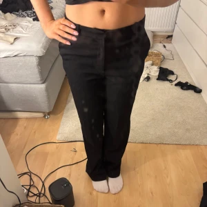 Svarta byxor från Cheap Monday - Snygga svarta byxor från Cheap Monday med en klassisk straight passform. Perfekta för en stilren look. Tillverkade i en blandning av bomull och polyester för komfort och hållbarhet.