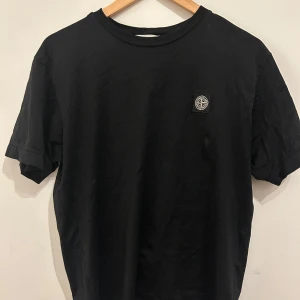 Svart t-shirt från Stone Island, storlek M  - Säljer en stilren svart t-shirt från Stone Island storlek M är ca 174cm och den sitter lite större på mig