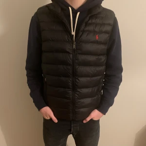 Ralph Lauren väst - Säljer en Ralph Lauren väst som är i mycket bra skick. Storlek: M. Färg: svart. Vårt pris: 1399. Nypris: 2300. Hör av er för fler bilder eller vid funderingar!