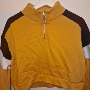 Tröja  - Tröjan har svarta och vita detaljer på ärmarna och en croppad passform. Garderobsrensning så kika gärna på övriga auktioner. 