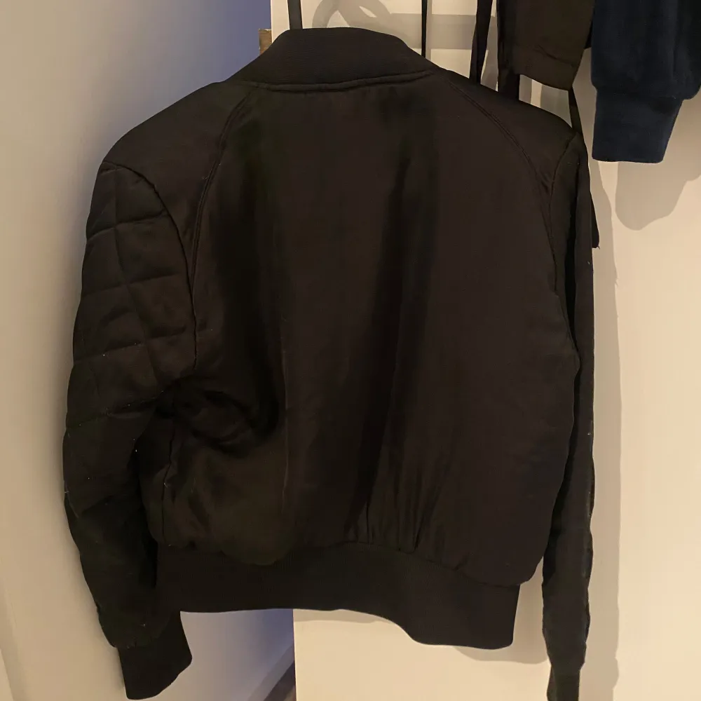 Säljer en svart bomberjacka från H&M Divided. Jackan har en dragkedja framtill och är långärmad. Den är i bra skick och perfekt för höst och vår. Enkel och stilren design som passar till det mesta.. Jackor.