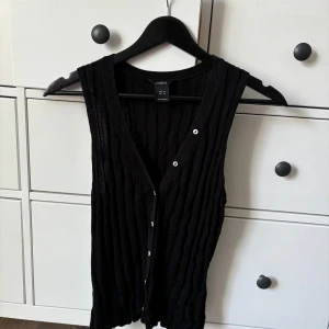 Stickad väst - Stickad väst från Lindex med benvita knappar. 