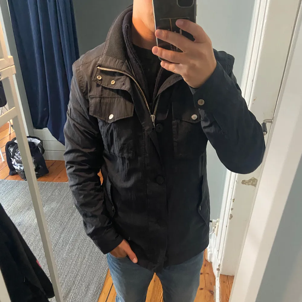 Stilren marinblå field jacket från J.Lindeberg i fint använt skick! Jackan är perfekt för hösten:) Modellen på bilden är ca. 180!. Jackor.