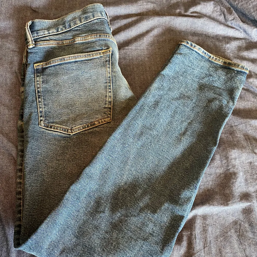 Säljer ett par snygga blå slim jeans från H&M. De är i storlek 30/32 och har en klassisk femficksdesign med dragkedja och knapp. Perfekta för både vardag och fest! Skick 8/10. Jeans & Byxor.