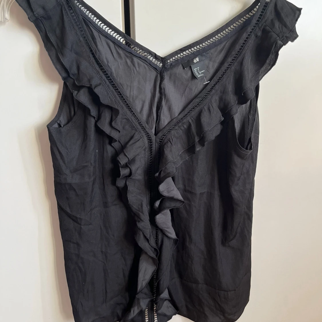 Svart ärmlös topp med volangdetaljer - 90