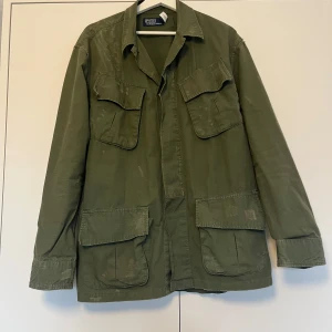 Grön jacka från Polo Ralph Lauren, tar bud! - Ralph Lauren distressed overshirt. Grön overshirt med “använd” look, ska se sliten ut med lappar på armbågarna. Storlek M, fits L. Riktigt schysst jacka som jag köpte från Ralph Lauren online i somras, men som inte kommit till särskilt mycket användning. Mycket bra skick. Nypris ca 6-7000 kr. Bara att höra av sig vid frågor! Tar Bud! 