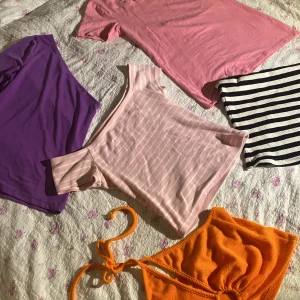 Klädpaket sommar/vår toppar - Säljer alla dessa i paket eller enskilt. Märkena bikbok hm nelly, Stl xs på den lila toppen, m på den orangea, S på den rosa randiga, xs/s på rosa tshirten &  den randiga bandeotopp är i stl L. 30kr st