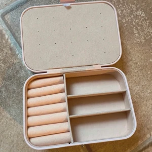 Rosa smyckeskrin - Helt nytt & oanvänt. Praktiskt och stilrent rosa smyckeskrin med flera fack för förvaring av smycken. Insidan har plats för ringar och små fack för andra smycken. Perfekt för att hålla ordning på dina favoritsmycken hemma eller på resan.