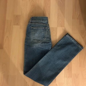 Blå jeans från Levi's - Snygga blå jeans från Levi's med klassisk femficksdesign och en rak passform. De har en knappgylf och är tillverkade i slitstarkt denim. Perfekta för en avslappnad stil.