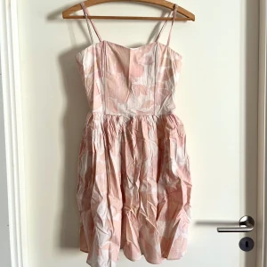 Bomullsklänning med korsett - Blommig miniklänning med korsett midja, fluffig nederdel och tunna axelband! Klänningen har blixtlås på baksidan, och går lite längre ner än vanliga miniklänningar, en bit över knäna på mig (jag är 174 cm). Har använts fåtal gånger. Alla använda plagg tvättas noga innan leverans! Det är bara att skriva om du har några frågor! <3 